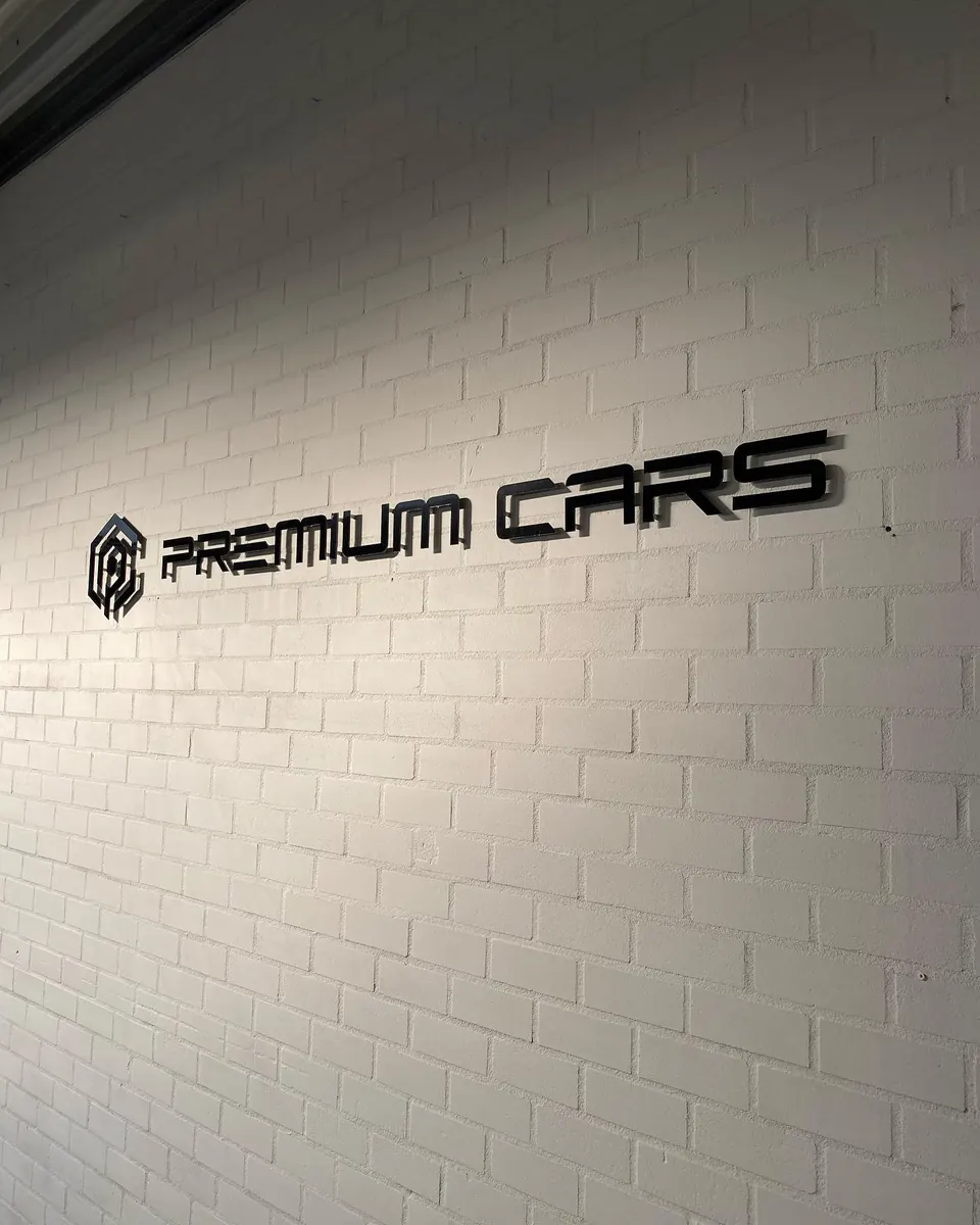 Logo van Premium Cars op de showroommuur