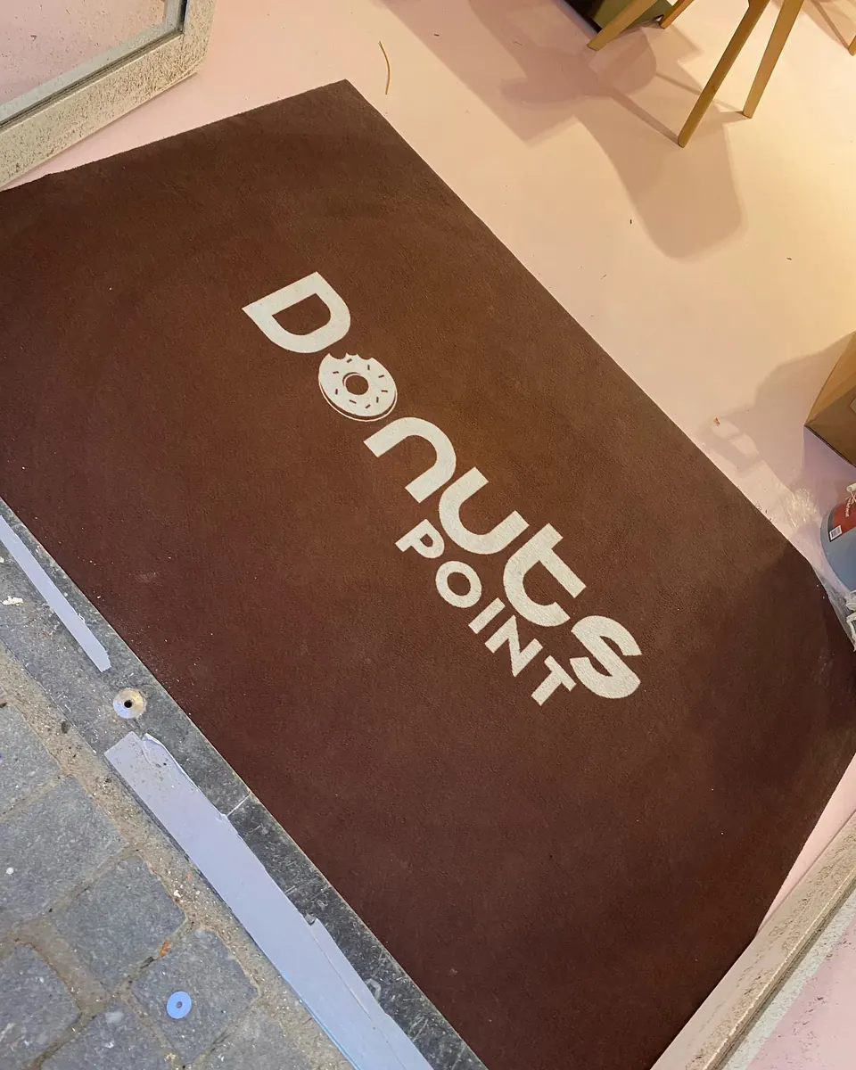Deurmat met het logo van Donuts Point