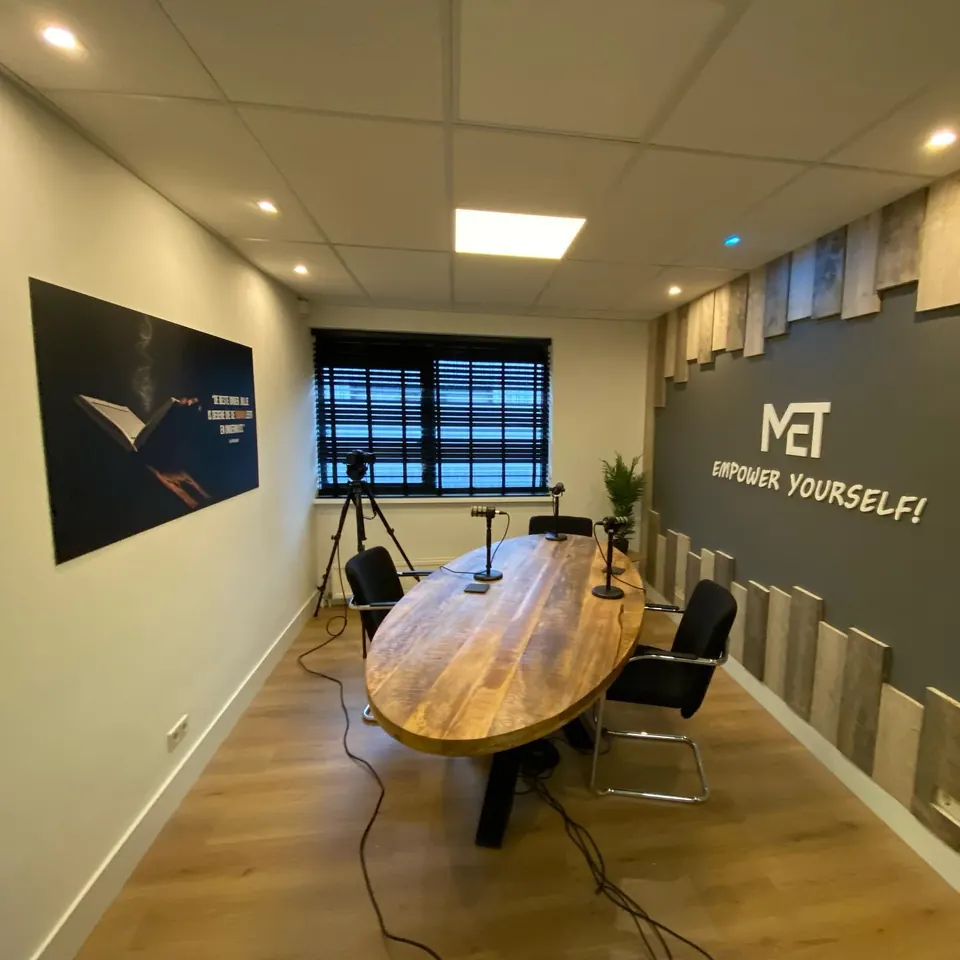 Studio met vergadertafel en logo op de wand