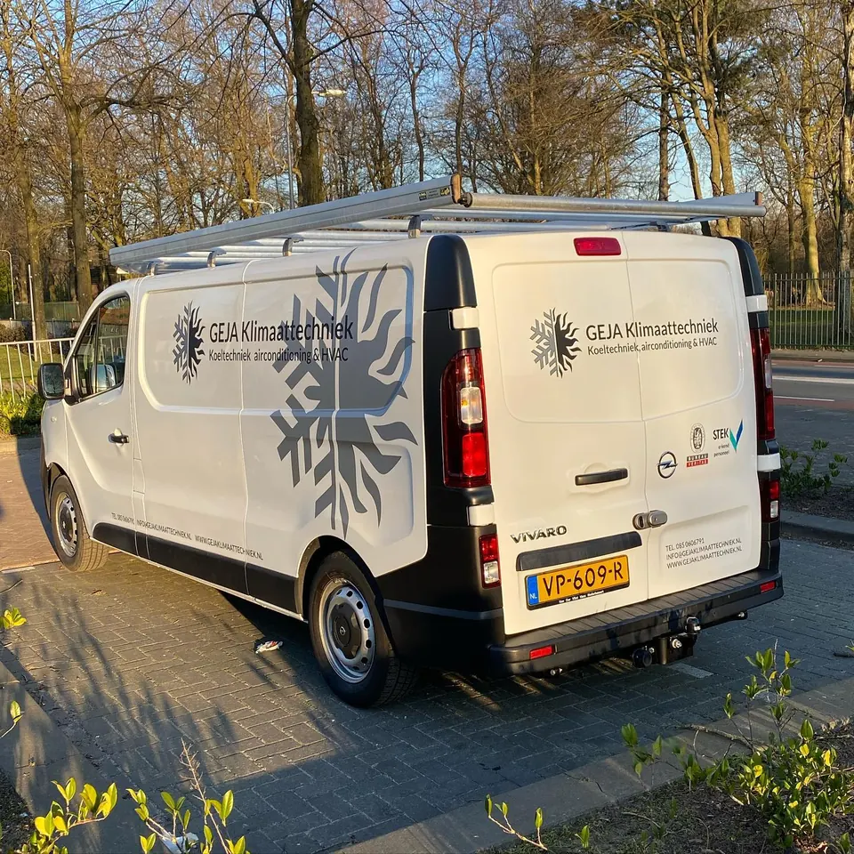 Witte bedrijfsbus met belettering over de zijkant